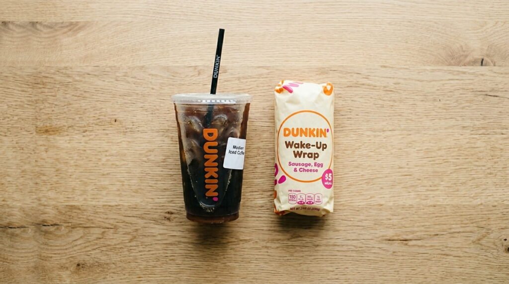 Dunkin $5 Meal Deal with medium iced coffee and Wake-Up Wrap on wooden surface