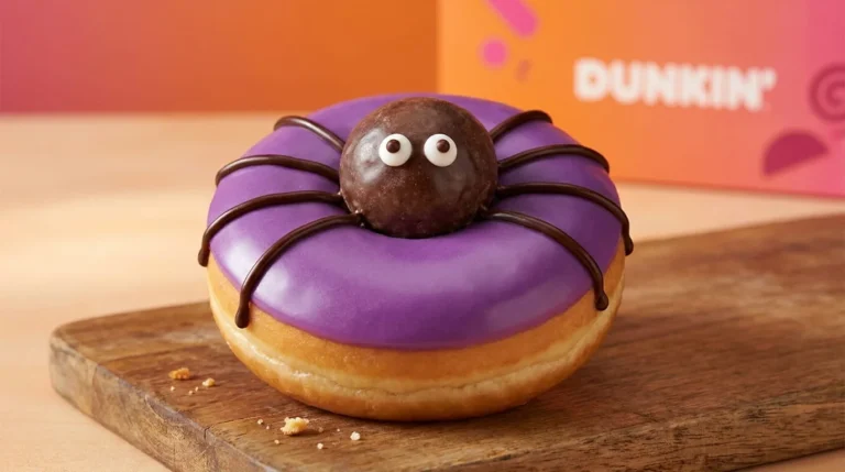Dunkin Spider Donut 2026 with purple icing, chocolate MUNCHKINS center, and chocolate spider legs