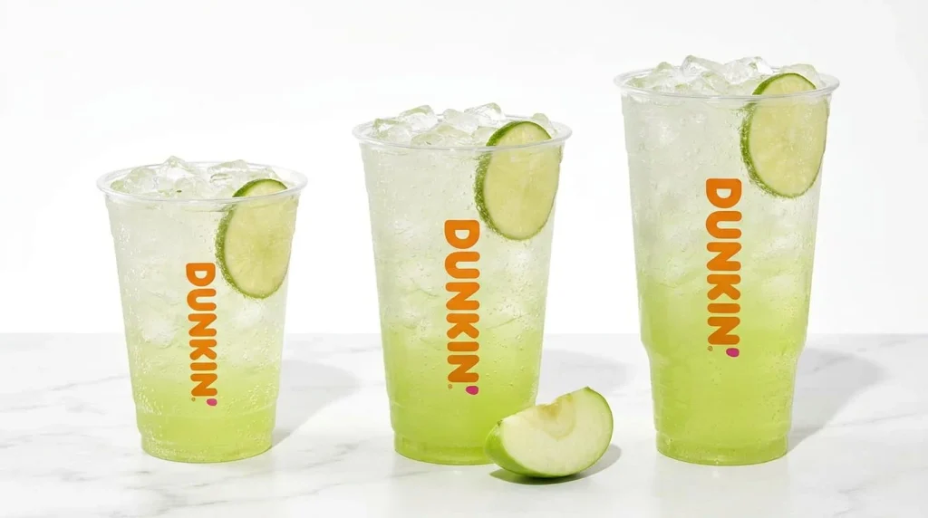 Small, medium and large green apple energy drinks side by side to compare calories and sugar
